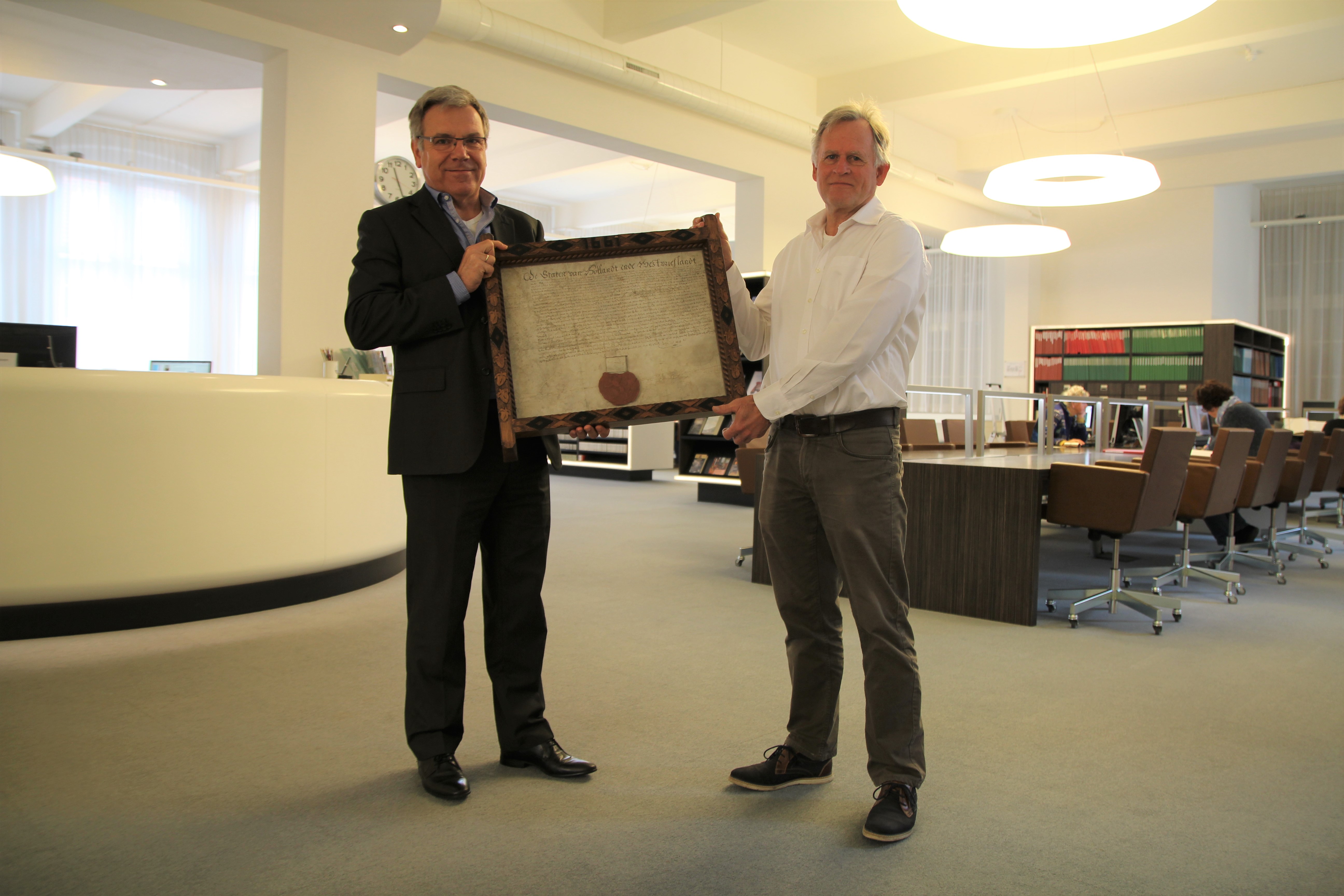  Arie Kaan overhandigd aan directeur Paul Post van het Regionaal Archief Alkmaar een zeventiende-eeuwse charter